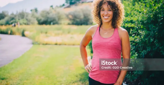 A pregnant woman visits the track in a park to get exercise.