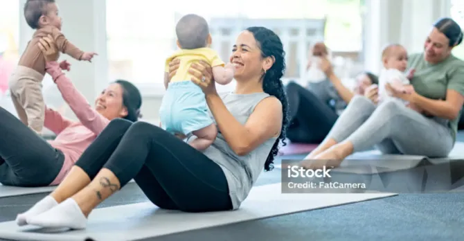 Mothers and babies participating in a fitness class together.