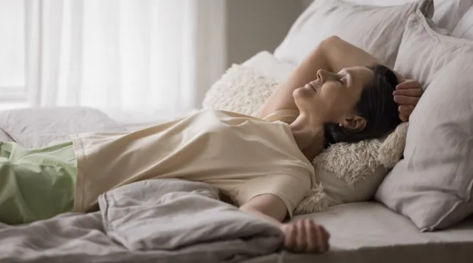 a woman lying comfortably in bed performing a body scan for mindfulness