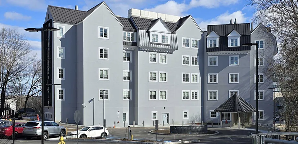 The front entrance of the UMass Memorial Medical Center North Pavilion, a gray building with a dark gray roof.
