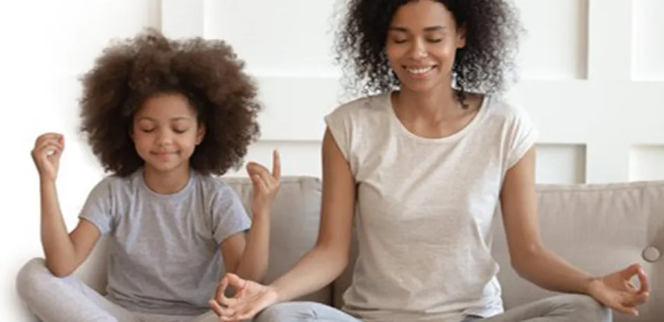 diverse mom and daughter mediating in their living room