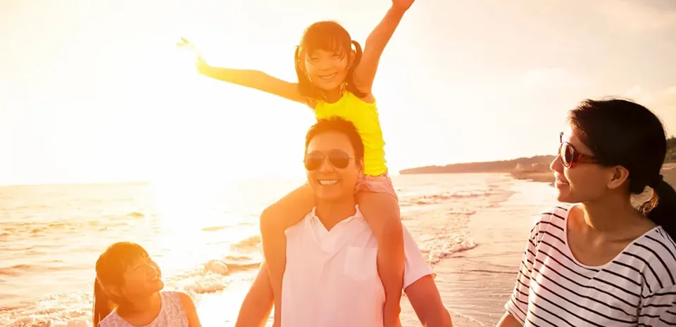 family walking along the ocean on the beach during the sunset