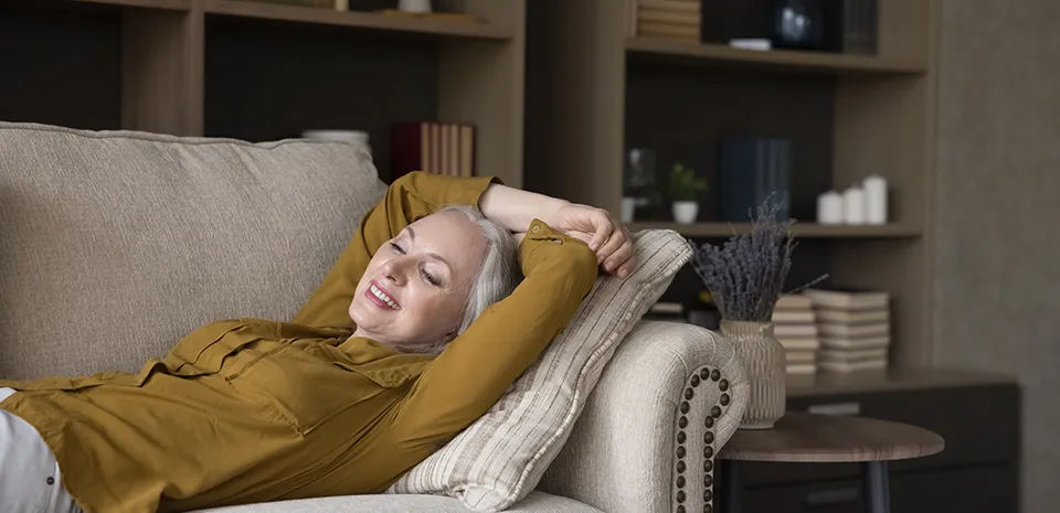 woman lying down and relaxing on living room couch
