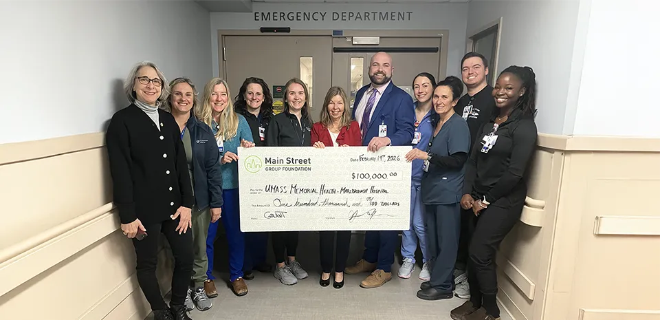 A group of caregivers at the Marlborough Campus hold up a large-size check from Community Bank in the amount of $100,000..