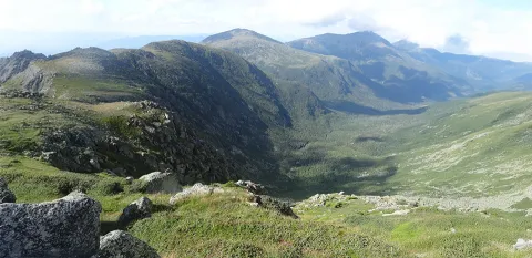 A large green valley is shown from atop a mountain on the Jewell Trail in the Presidential Range of the White Mountains.