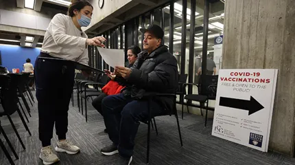 Disnarda Espinosa (left) and her husband, Roberto Bonilla, waited to get their flu shots at Boston City Hall.
