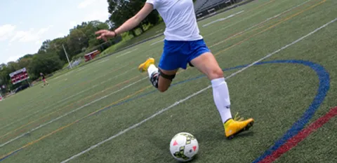 soccer player kicking soccer ball