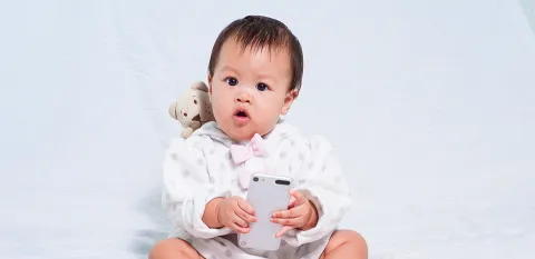 baby holding parent's cell phone