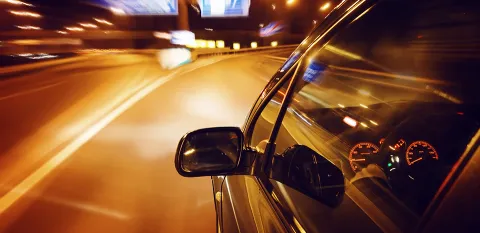 car driving down the road at night time
