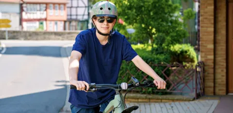 teen boy wearing proper equipment to prevent injuries while riding his bike