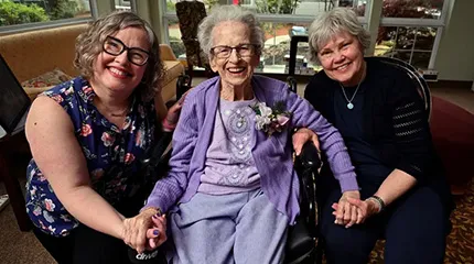 Carol Flynn, her godmother (June LaJeunesse) and her mother (Cheryl Flynn) hold hands and share a happy moment. 