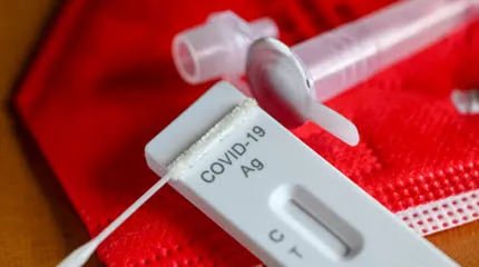 An antigen test to detect COVID-19 for self-testing is on a red mask. 