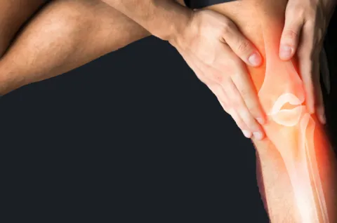 A closeup of hands holding a knee with the bones shown underneath the skin are on a black background.