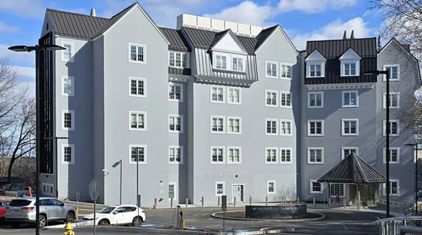 The front entrance of the UMass Memorial Medical Center North Pavilion, a gray building with a dark gray roof.