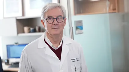 Dr. Richard Ellison stands near desks in his department at UMass Memorial Medical Center.