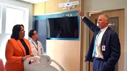 Dr. Eric Dickson, UMass Memorial Health president and CEO (right), shows Massachusetts Lt. Gov. Kim Driscoll (left) the North Pavilion's technology allowing patients virtual visits with providers from other facilities.