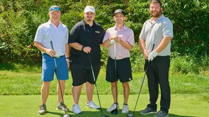 Milford CAT's team of four poses on the golf course.