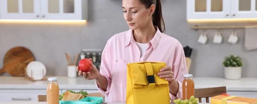 Woman at a kitchen counter prepping her balanced lunch with healthy foods 