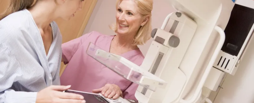 woman having mammogram talking with technician about the Tyrer Cuzick breast cancer screening tool