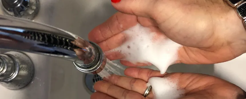 A close view of a woman's hands in a sink as she washes them