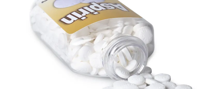 bottle of aspirin is tipped over with some pills outside of the bottle