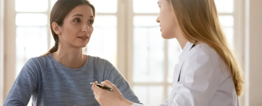 Woman with a genetic counselor at a desk talking about cancer genetic testing