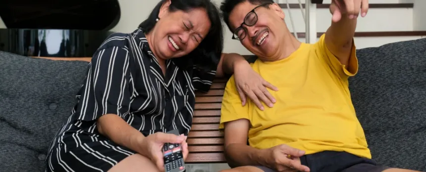 older couple watching TV and laughing which benefits heart health