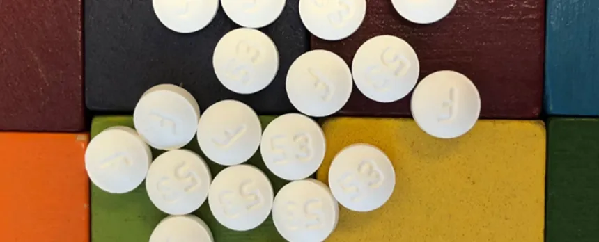 Multiple white pills are on top of different-colored blocks.
