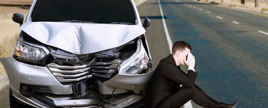 man getting in car crash and on the side of the road upset
