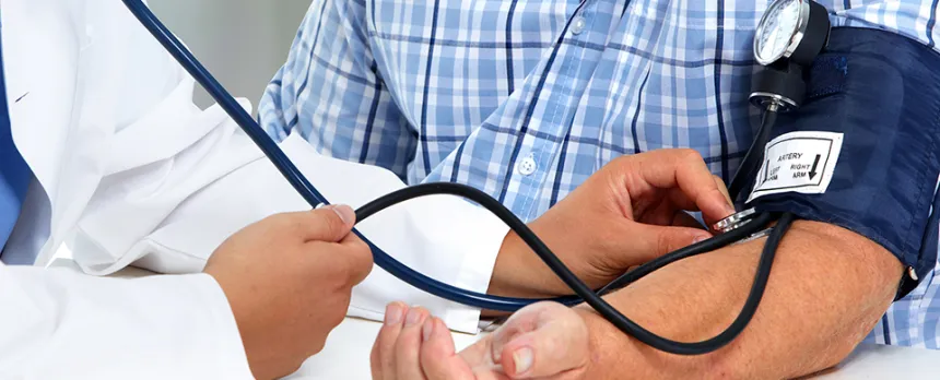 doctor taking patient's blood pressure