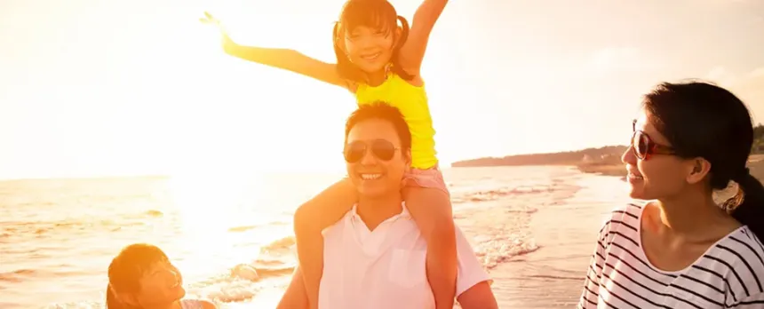 family walking along the ocean on the beach during the sunset