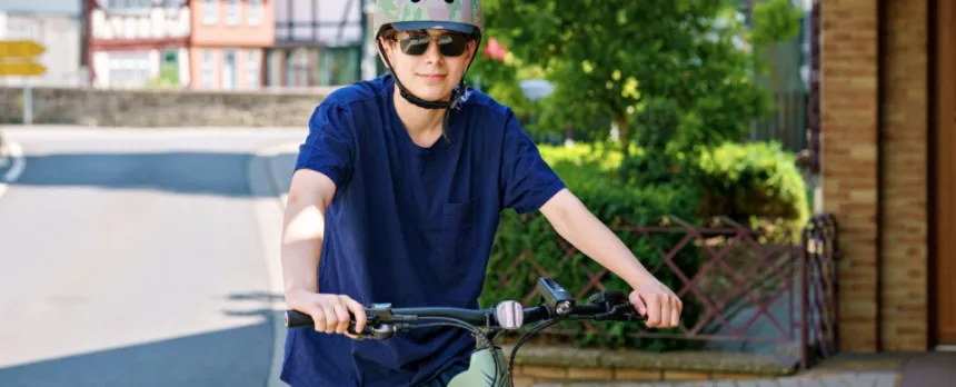 teen boy wearing proper equipment to prevent injuries while riding his bike