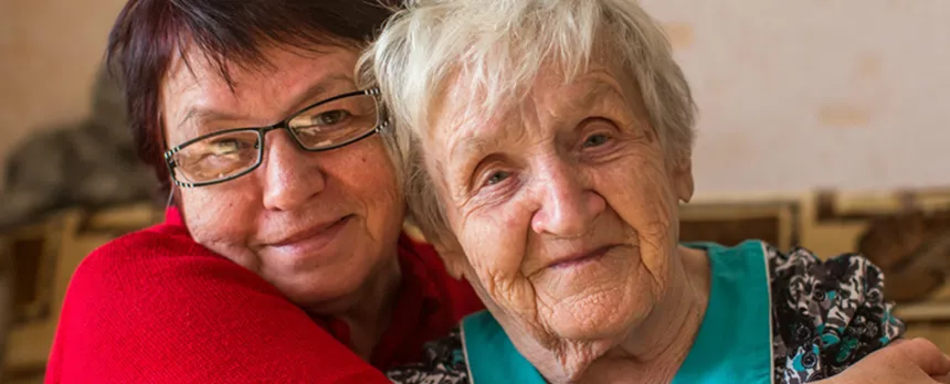 A woman is hugging a mature woman.