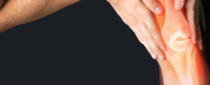 A closeup of hands holding a knee with the bones shown underneath the skin are on a black background.